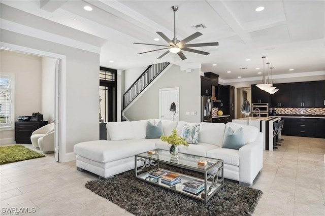 living room featuring plenty of natural light, stairs, visible vents, and beamed ceiling