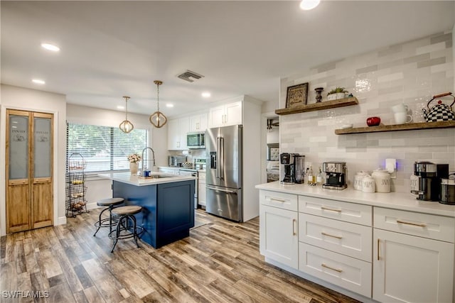 618 SE 26th St, Cape Coral, FL 33904 - kitchen with stainless steel appliances, decorative backsplash, a sink, white cabinetry, and light countertops