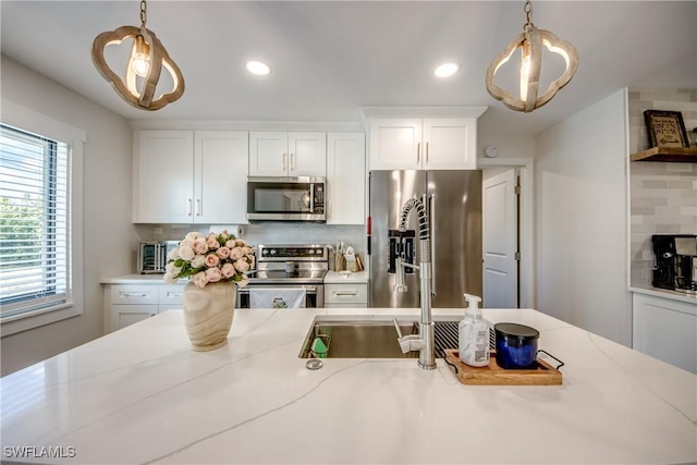 618 SE 26th St, Cape Coral, FL 33904 - kitchen featuring stainless steel appliances, backsplash, pendant lighting, white cabinetry, and recessed lighting