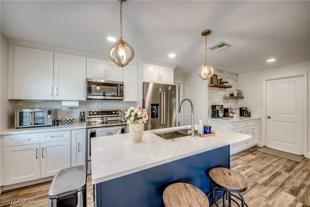 618 SE 26th St, Cape Coral, FL 33904 - kitchen featuring appliances with stainless steel finishes, tasteful backsplash, light wood-style floors, a sink, and recessed lighting