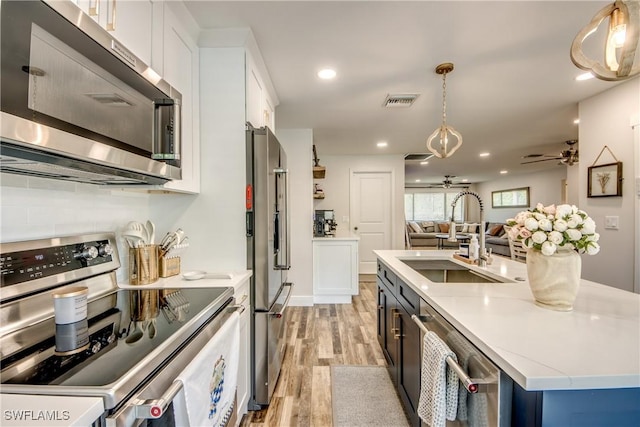 618 SE 26th St, Cape Coral, FL 33904 - kitchen with appliances with stainless steel finishes, a sink, ceiling fan, light wood-style floors, and light countertops