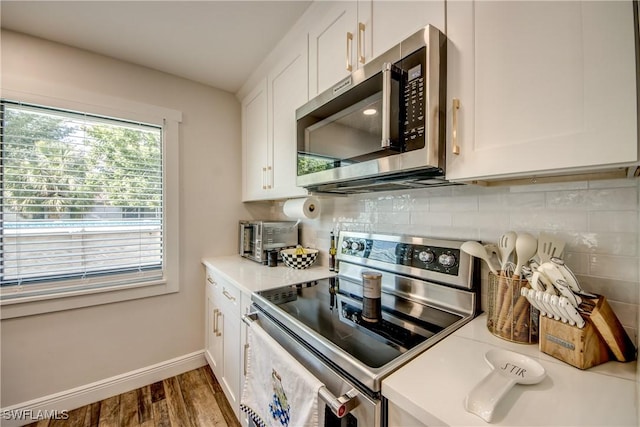 618 SE 26th St, Cape Coral, FL 33904 - kitchen with stainless steel appliances, wood finished floors, white cabinetry, and baseboards