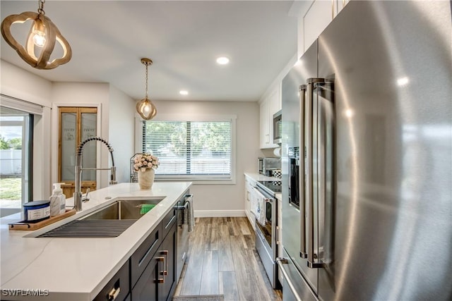 618 SE 26th St, Cape Coral, FL 33904 - kitchen with stainless steel appliances, a sink, white cabinets, light countertops, and wood finished floors