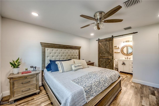 618 SE 26th St, Cape Coral, FL 33904 - bedroom with a barn door, light wood-style floors, baseboards, ensuite bath, and recessed lighting