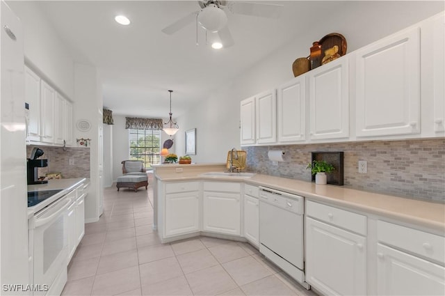 kitchen featuring white appliances, a peninsula, light tile patterned flooring, a sink, and light countertops