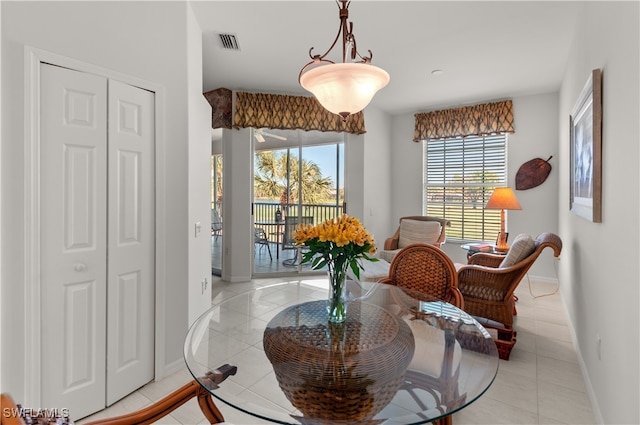 dining space featuring light tile patterned floors, visible vents, and baseboards