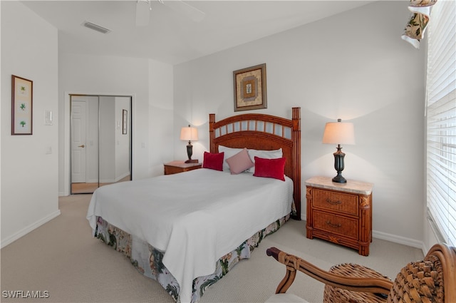 bedroom featuring visible vents, a closet, baseboards, light colored carpet, and ceiling fan