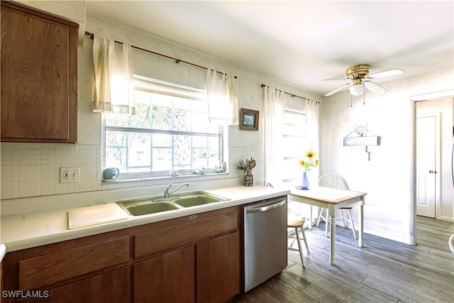 kitchen featuring a sink, dishwasher, wood finished floors, and light countertops