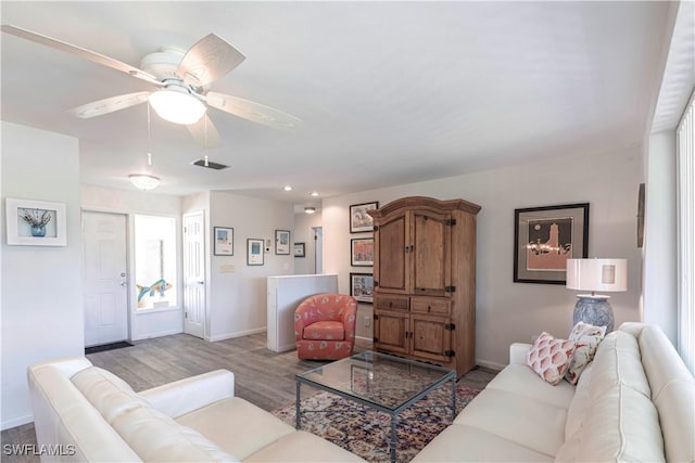 living room featuring a ceiling fan, wood finished floors, and baseboards