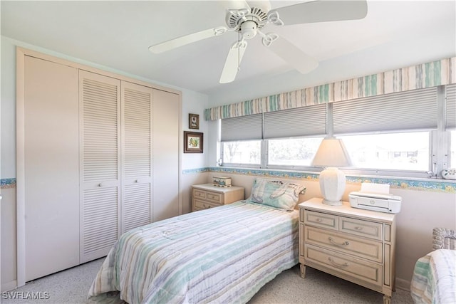 bedroom with a closet, light speckled floor, and a ceiling fan