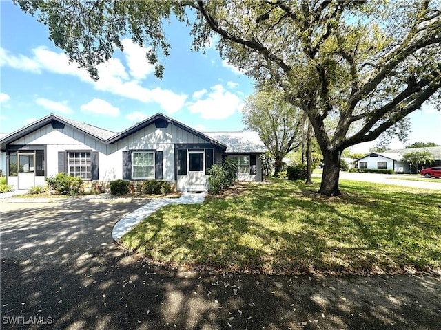 single story home featuring a front lawn