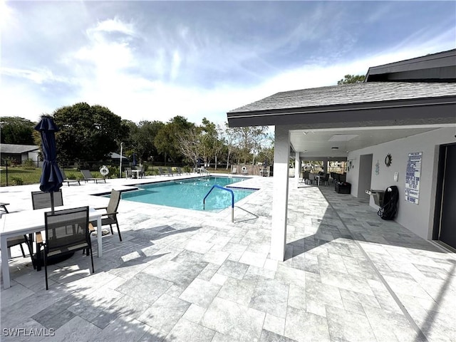 community pool with fence and a patio