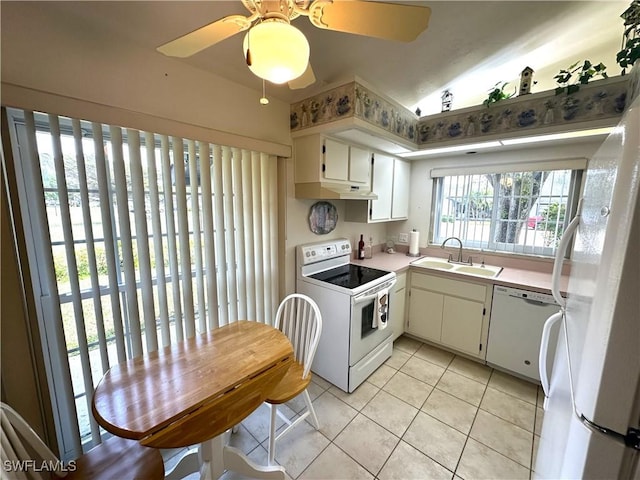 kitchen featuring light tile patterned floors, white appliances, a sink, white cabinetry, and light countertops