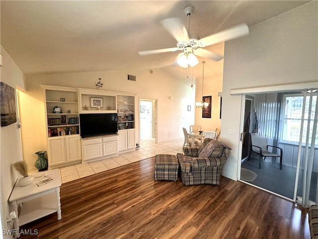 living area with ceiling fan, visible vents, vaulted ceiling, and wood finished floors