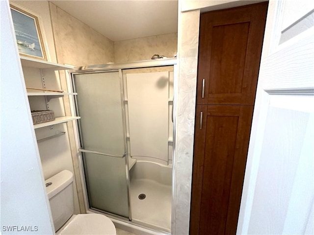 full bath featuring a stall shower and toilet