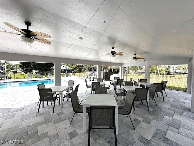 view of patio with a ceiling fan, fence, a fenced in pool, and outdoor dining space