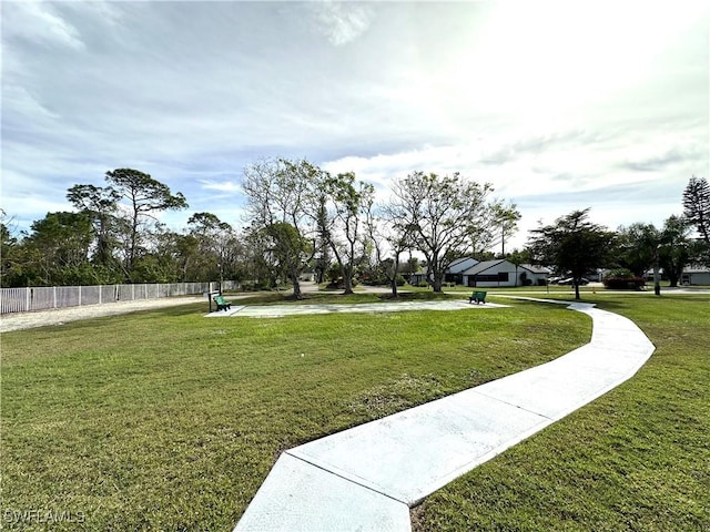 view of property's community featuring fence and a lawn