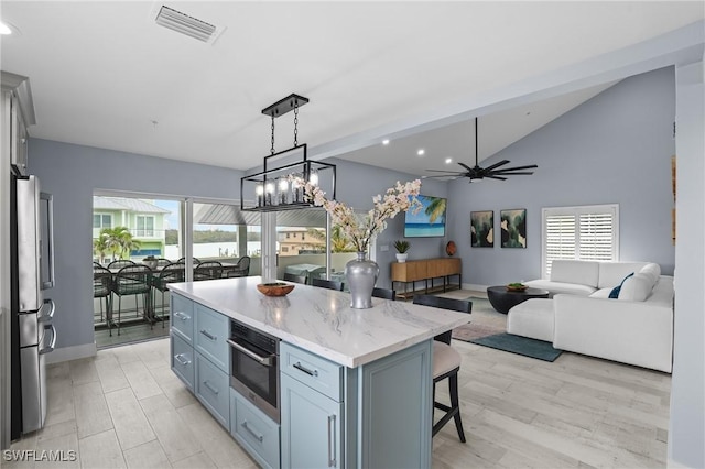 kitchen featuring visible vents, a kitchen island, appliances with stainless steel finishes, a kitchen breakfast bar, and plenty of natural light