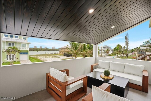 view of patio with an outdoor living space, a water view, and a balcony