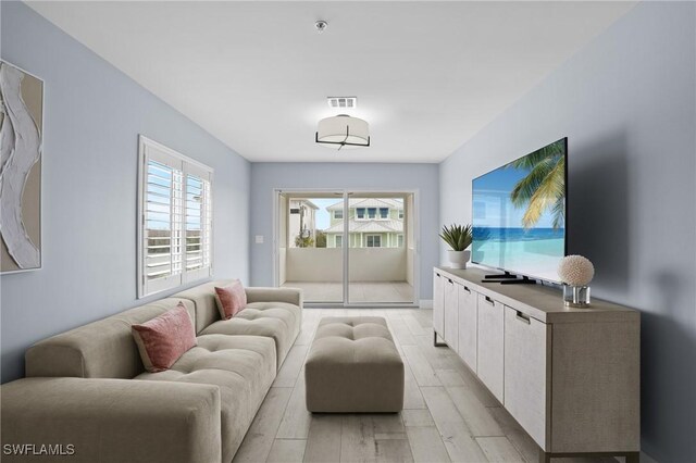 living room featuring light wood-style floors and visible vents