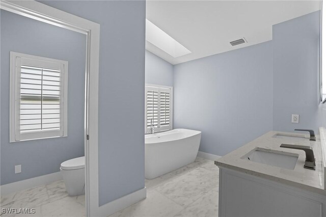 full bathroom featuring visible vents, toilet, marble finish floor, a sink, and a freestanding bath