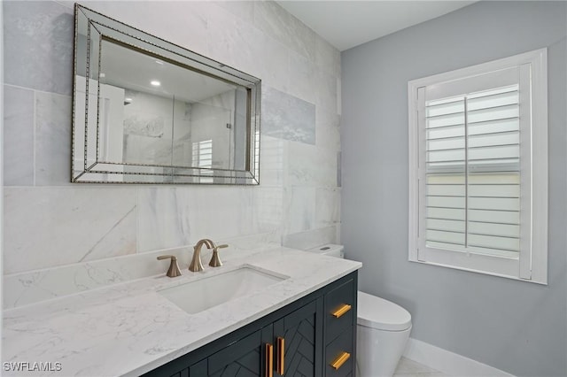 full bathroom featuring a shower, baseboards, toilet, and vanity