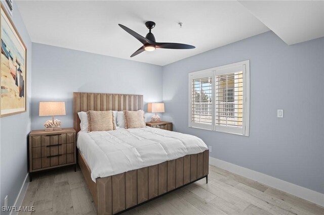 bedroom with light wood-type flooring, baseboards, and a ceiling fan