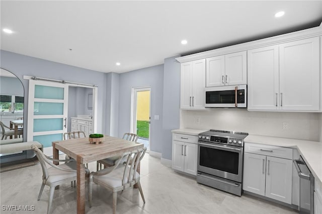 kitchen with electric range, recessed lighting, white cabinetry, and light countertops