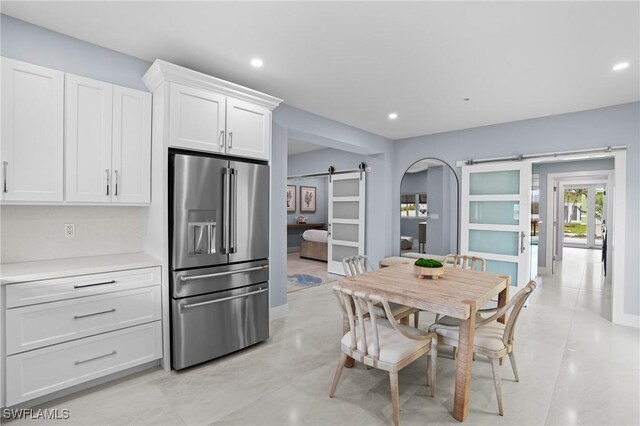 dining space featuring a barn door and recessed lighting