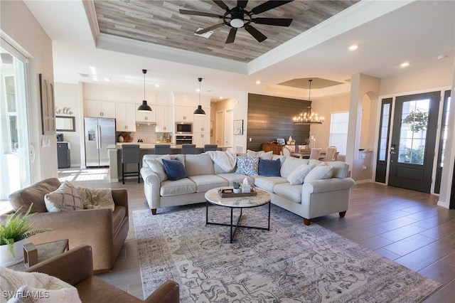 living room featuring recessed lighting, crown molding, wood ceiling, and a raised ceiling