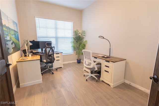 office area featuring baseboards and light wood-style flooring