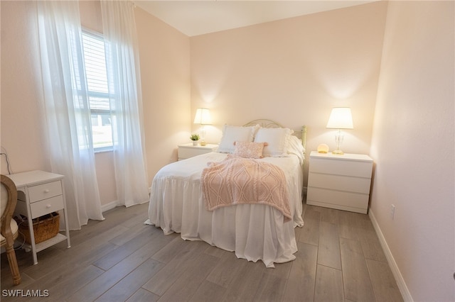 bedroom featuring baseboards and light wood finished floors