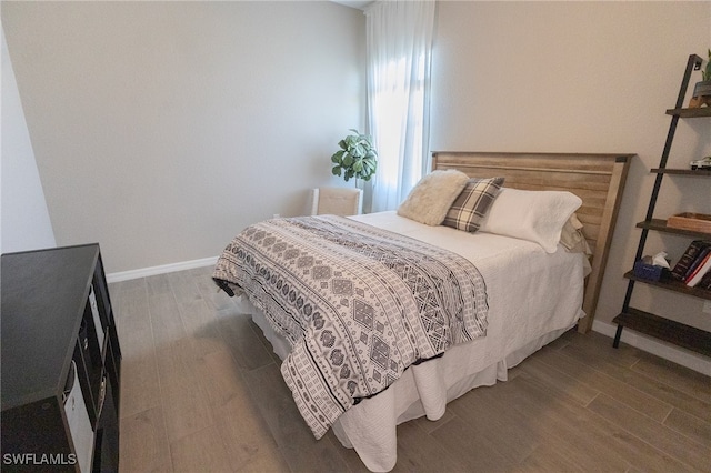 bedroom with wood finished floors and baseboards