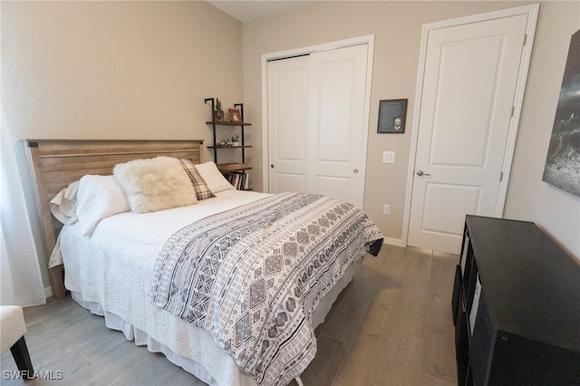 bedroom featuring a closet, baseboards, and light wood-style floors