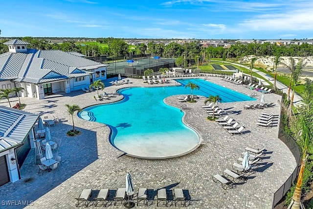 pool with a patio area and fence