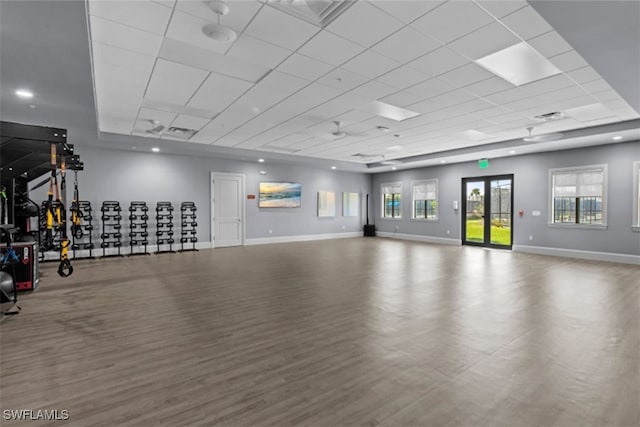 interior space featuring visible vents, a paneled ceiling, baseboards, and wood finished floors