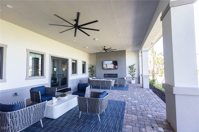 view of patio / terrace featuring a ceiling fan, an outdoor living space, and french doors