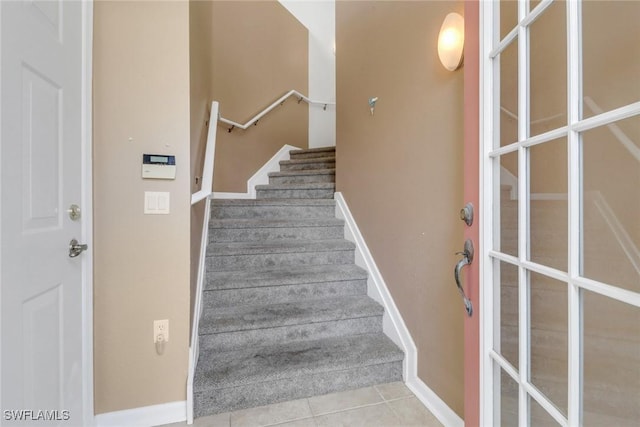 stairs featuring baseboards and tile patterned flooring