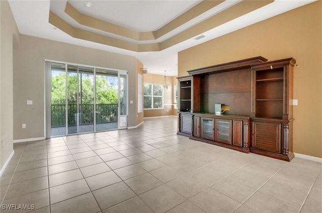 17498 Old Harmony Dr Unit 202, Fort Myers, FL 33908 - unfurnished living room with visible vents, a raised ceiling, baseboards, and light tile patterned flooring
