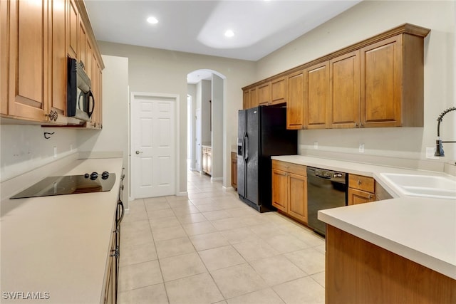 17498 Old Harmony Dr Unit 202, Fort Myers, FL 33908 - kitchen featuring black appliances, brown cabinets, arched walkways, and a sink