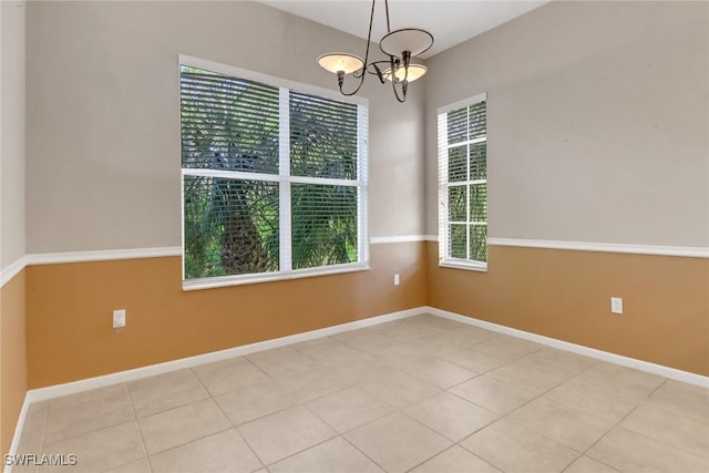 17498 Old Harmony Dr Unit 202, Fort Myers, FL 33908 - spare room featuring an inviting chandelier, light tile patterned floors, and baseboards