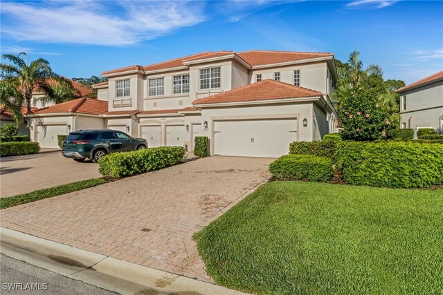 17498 Old Harmony Dr Unit 202, Fort Myers, FL 33908 - mediterranean / spanish-style house featuring stucco siding, a tile roof, decorative driveway, a front yard, and an attached garage