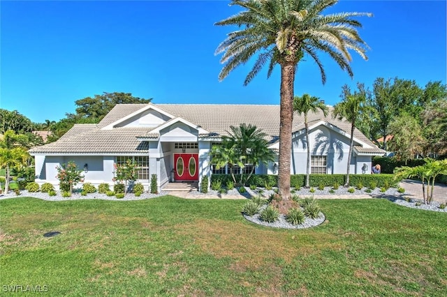 view of front of property with a front lawn and a tile roof