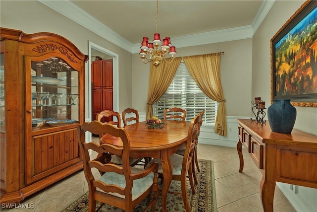 dining area featuring ornamental molding, a wainscoted wall, light tile patterned floors, and a chandelier