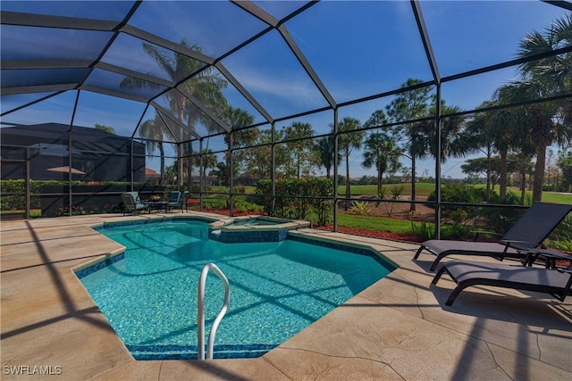 view of pool featuring a lanai, a patio area, and a pool with connected hot tub