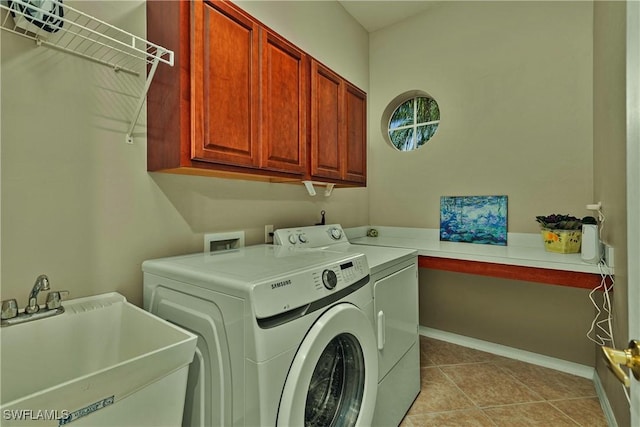 laundry room featuring a sink, washer and dryer, cabinet space, light tile patterned flooring, and baseboards