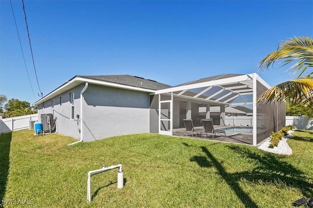 rear view of property with stucco siding, a lawn, a fenced backyard, a fenced in pool, and a lanai