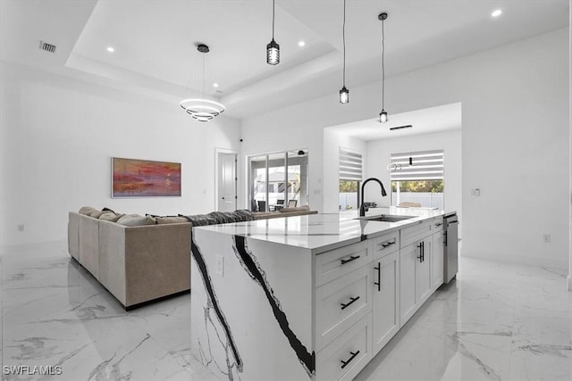 kitchen featuring visible vents, recessed lighting, marble finish floor, a raised ceiling, and a sink