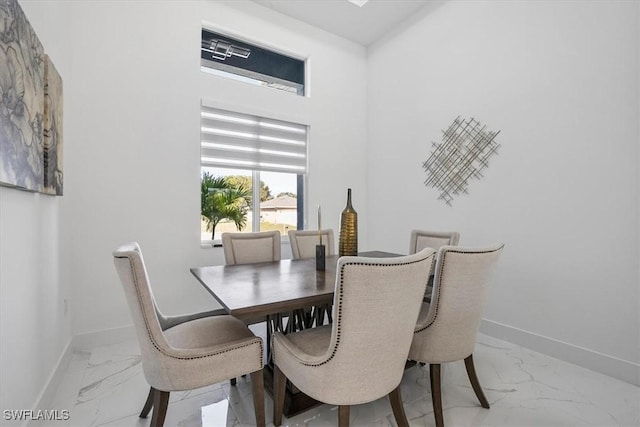 dining space with marble finish floor and baseboards