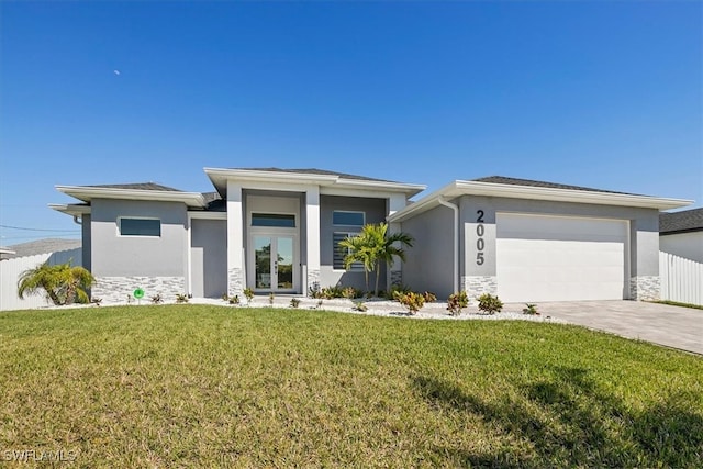 prairie-style home featuring stucco siding, stone siding, a front lawn, and driveway